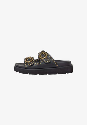 Schwarze Riemensandalen mit zwei Schnallenriemen, verziert mit goldenen Nieten, ausgestattet mit einer dicken Plateausohle und texturiertem Profil.