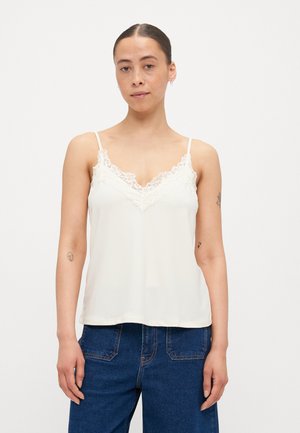 Cami-Top aus ivory Satin mit Spitzenbesatz entlang des Ausschnitts, dünnen verstellbaren Trägern und lockerer Passform, kombiniert mit blauen Jeans.