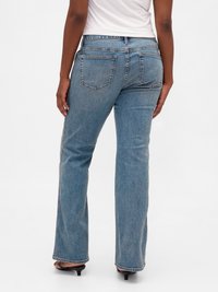 Jean flare en denim bleu avec une taille mi-haute, doté de deux poches arrière et d'une texture légèrement délavée.