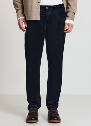 Marineblaue Cordhosen mit schmaler Passform, 5-Taschen-Design und Knopfverschluss, kombiniert mit braunen Schnürschuhen. Glatte Textur sichtbar.