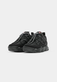 Black athletic shoes with gray laces and texture detail, positioned side by side on a plain white background.