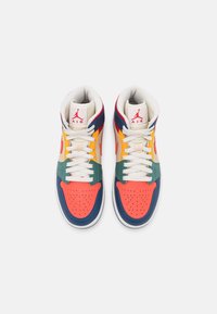 Par de zapatillas altas coloridas con cordones blancos, punteras rojas, paneles laterales verdes y amarillos, y logotipos de Jumpman Air rojos en lengüetas beige.