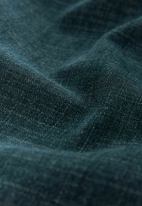 Tumeroheline teksariidest kangas, millel on pehme tekstuur, näidates värvitoonide õrna varieeruvust ja kerget läiget, mis viitab kvaliteedile ja vastupidavusele.