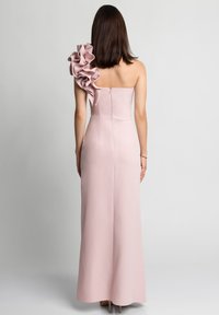 Różowa sukienka do ziemi o dopasowanym kroju, na jedno ramię, z wyraźnym falbaniastym akcentem na ramieniu. Zamek błyskawiczny z tyłu.