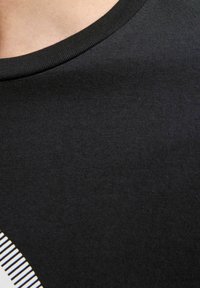 Zwarte katoenen t-shirt met een geribde ronde halslijn en een gladde textuur; bevat een witte gestreepte grafische detail aan de onderrand.