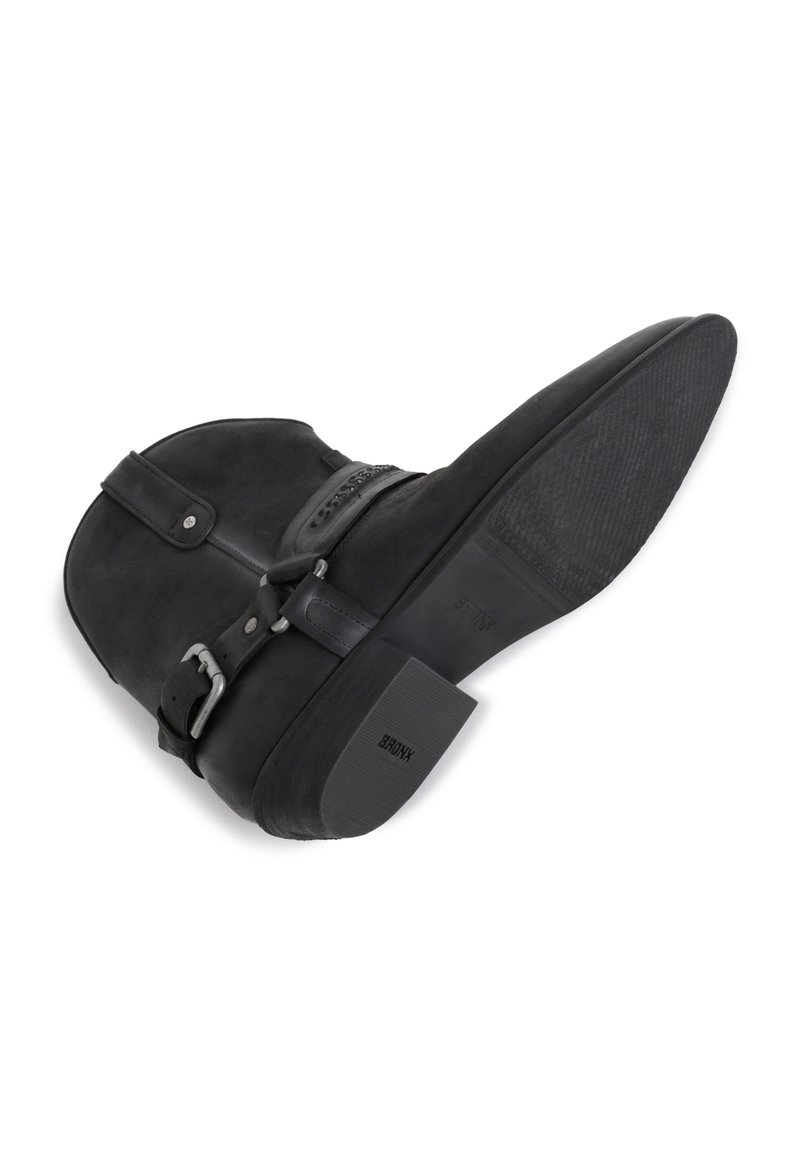 Czarne botki za kostkę z zamszowym wykończeniem, okrągłym noskiem, detalem z klamrą oraz niskim blokowym obcasem. Teksturowana podeszwa dla lepszej przyczepności.