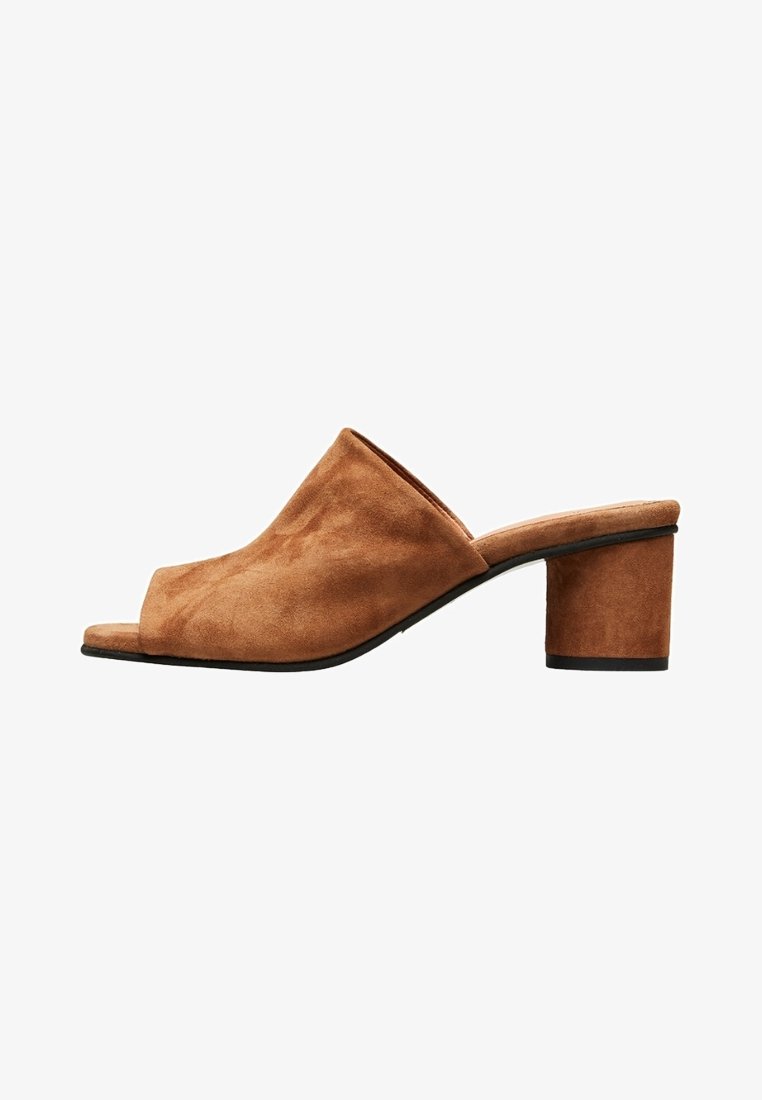 Mules ouvertes en daim marron avec un petit talon carré. Texture lisse, design minimaliste et un empeigne large pour le confort et la respirabilité.