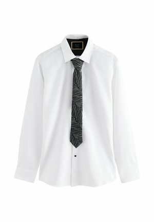 Witte lange mouwen shirt met een zwarte gestippelde das met gebogen lijnen, knoopsluiting aan de voorkant en een klassiek kraagontwerp.