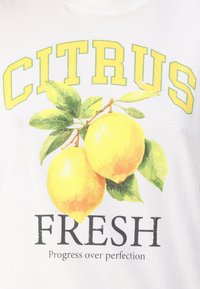 Balta marškinėliai su dviem geltonomis citrinomis ir žaliais lapais grafika, viršuje esantis tekstas "CITRUS FRESH", apačioje - "Progresas virš tobulumo".