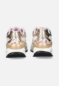 Un par de zapatillas doradas y blancas con acentos en rosa y gris, suelas negras y forros acolchados en lila, mostradas desde atrás sobre un fondo blanco.