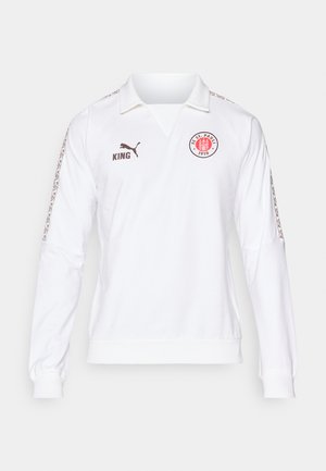 Biely dlhý rukáv dres s golierom polo, hnedým logom a textom, vzorované akcenty na rukávoch a rebrované manžety.