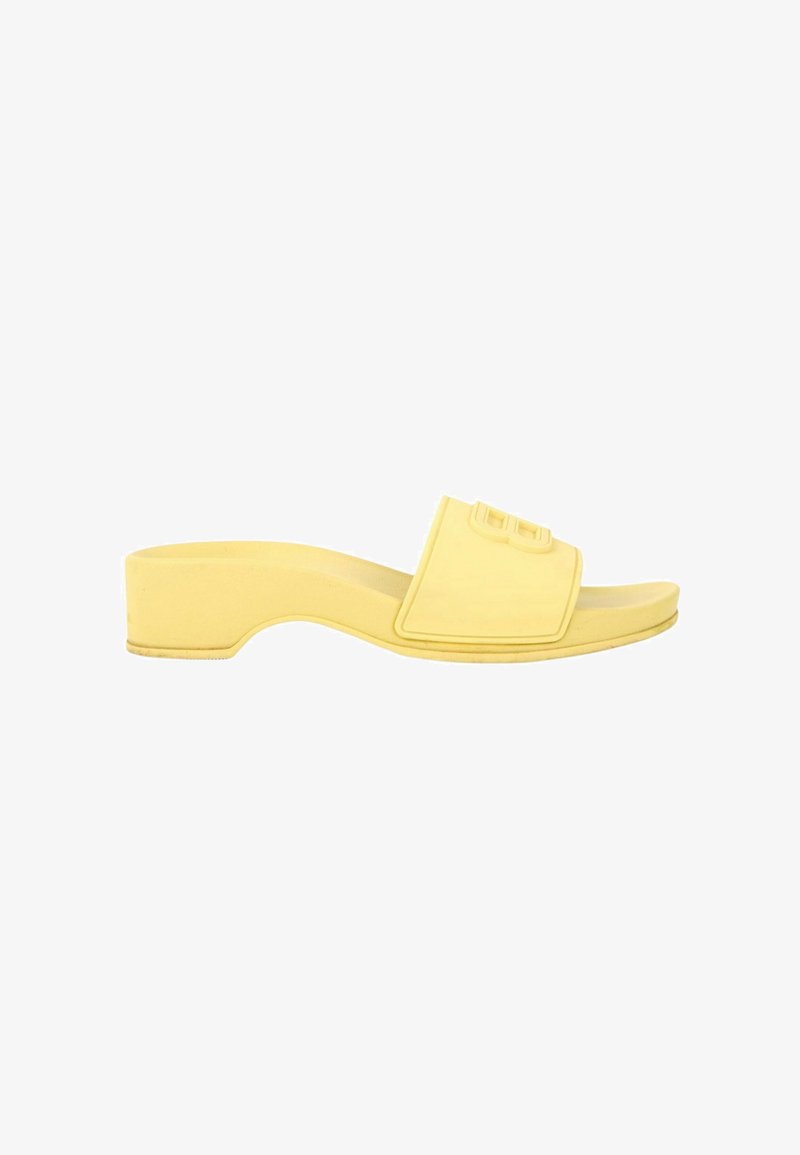 Sandale slide jaune à bout ouvert avec petit talon bloc et large bride portant un logo double B en relief.