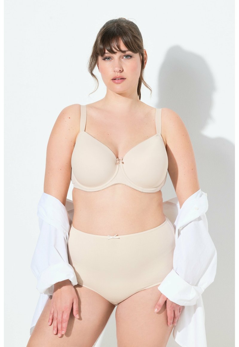 Beige lingerieset met een gladde, gevormde beha en hooggesneden slip, beide met fijne afwerking en een klein strikje accent.