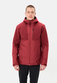 Veste imperméable rouge avec capuche, fermeture éclair devant et poche poitrine. Dispose de poignets réglables et d'une texture lisse avec un détail de logo.