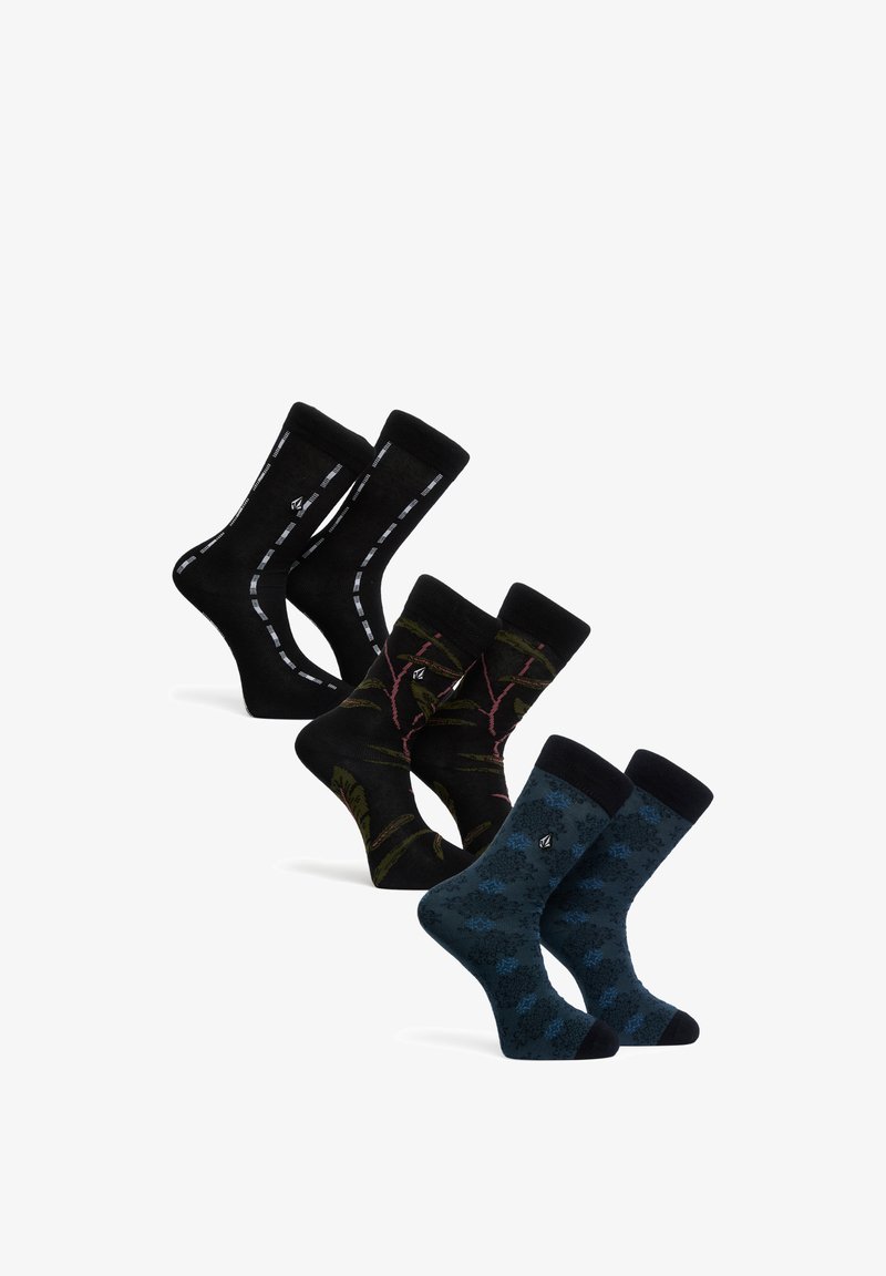 Trois paires de chaussettes mi-mollet avec différents motifs : noires avec des lignes blanches, noires avec des fleurs vertes et roses, et bleu foncé avec des fleurs noires et bleues.