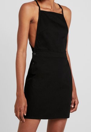 Zwarte denimjurk met een aansluitende pasvorm, verstelbare schouderbandjes en zijknopen. Glad oppervlak met een minimalistisch ontwerp.