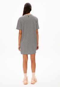 Gestreiftes, kurzärmliges Kleid in Schwarz und Weiß. Mit einem Rundhalsausschnitt und einem lockeren Schnitt, versehen mit einem kleinen Logo auf der Rückseite. Lässiges Design.