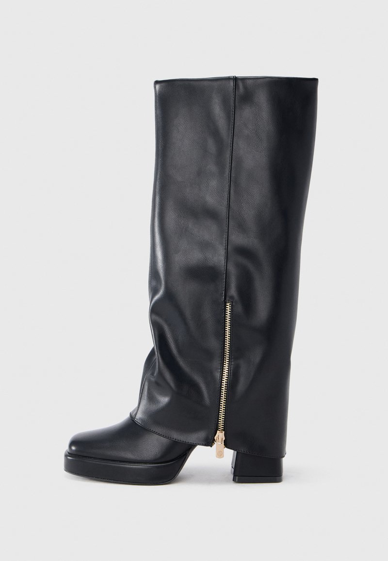 Black knee-high leather boot with chunky heel and gold zipper detail on the side against a white background.