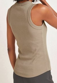 Débardeur côtelé kaki avec un col montant et un design sans manches. Présente un ourlet incurvé et une texture lisse, adapté à un usage décontracté.