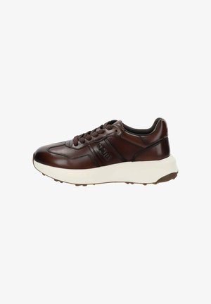 Zapatilla de cuero marrón oscuro con suela blanca gruesa, parte frontal con cordones y logotipo embosado en el costado, mostrada de perfil sobre un fondo blanco.