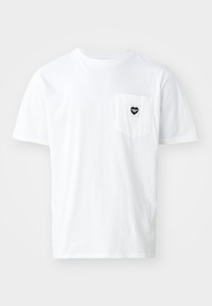 T-shirt bianco in cotone con scollo rotondo e maniche corte, caratterizzato da un piccolo logo a forma di cuore nero sulla tasca. Design semplice, vestibilità standard.