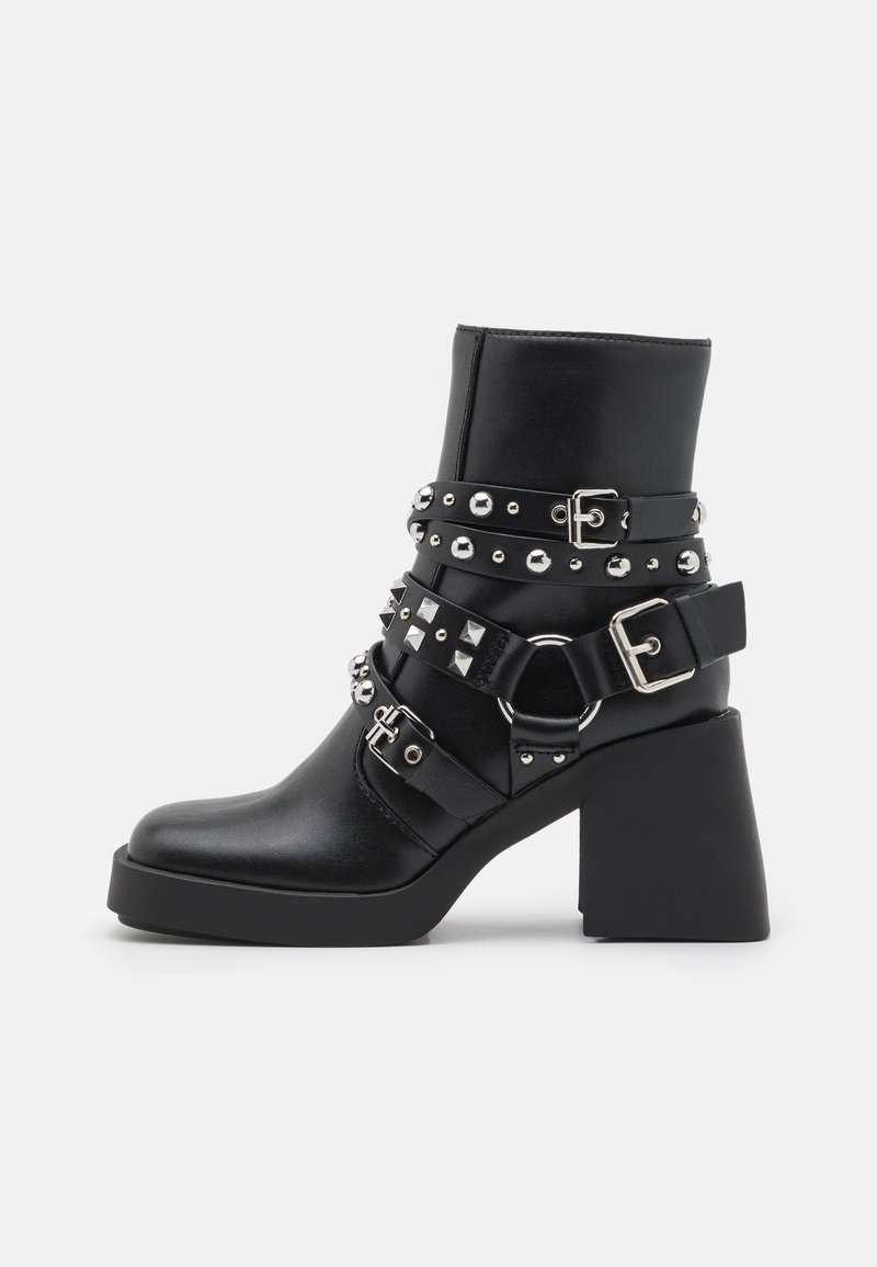 Black ankle boots with a chunky block heel, featuring multiple studded straps and metallic hardware for added detail. Smooth faux leather finish.