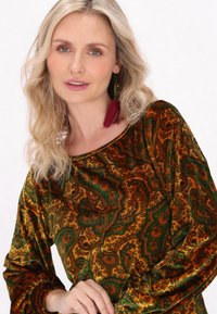 Langärmliges Oberteil aus plüschigem Material mit grün-goldenem Paisleymuster, elegantem Fall und weitem Ausschnitt, das mit einem lebhaften Druck und einer interessanten Textur versehen ist.