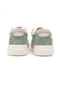 Green suede sneakers with a beige suede accent on the heel. Thick white rubber sole. Vibrant patterned interior lining.