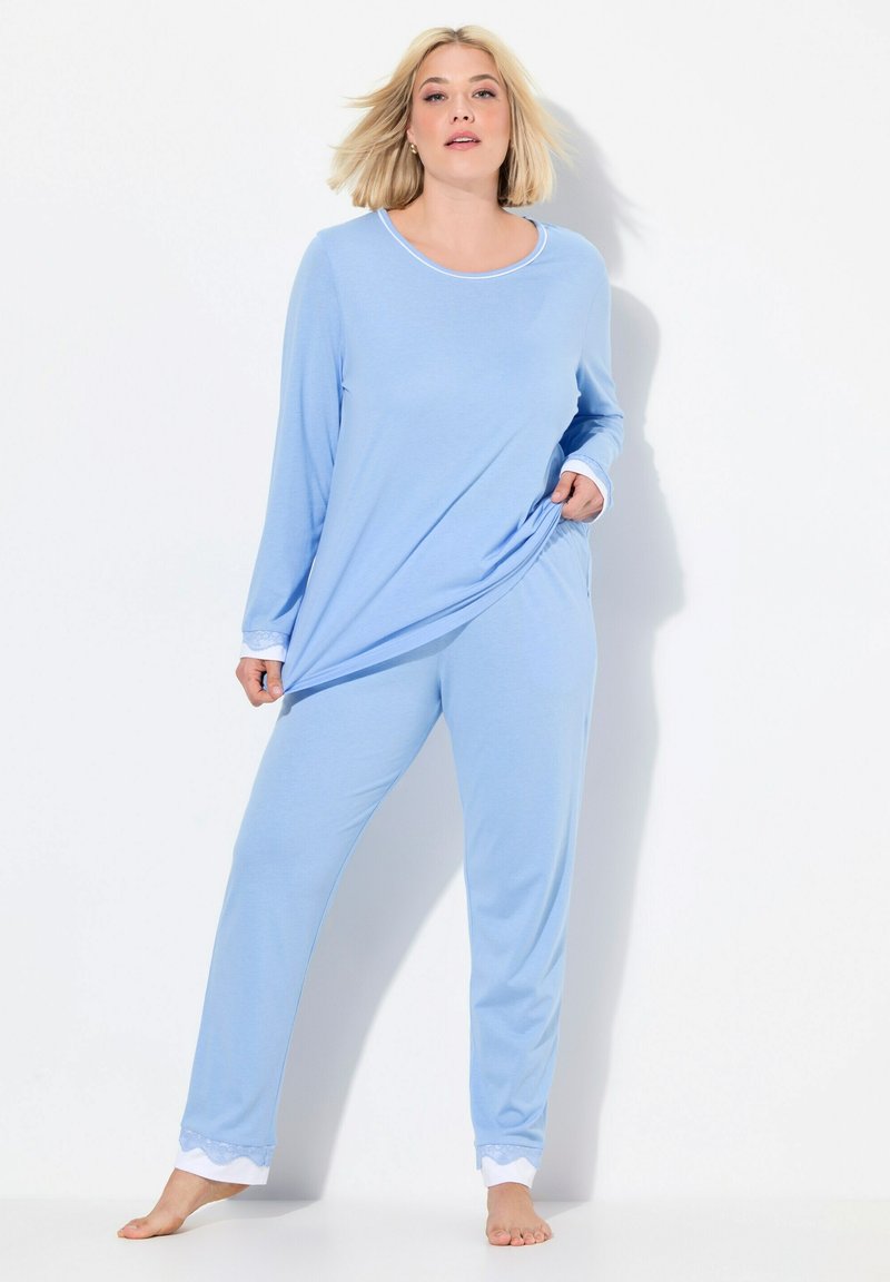 Blå långärmad pyjamas-set gjort av mjuk bomull med rund halsringning och vita spetsdetaljer vid ärmar och byxkanter. Taperad passform.