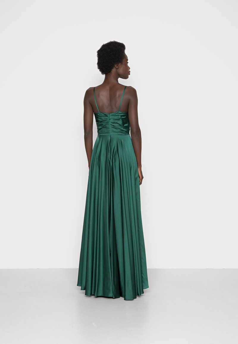 Długa zielona satynowa sukienka z dopasowanym korpusem i plisowanym dołem, z cienkimi ramiączkami i marszczonym szczegółem z tyłu. Gładka, błyszcząca struktura.