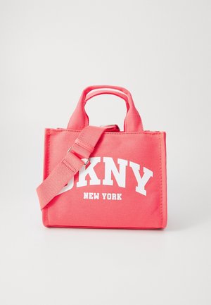 Růžová plátěná kabelka s krátkými rukojeťmi a nastavitelným ramenním popruhem. Obsahuje výrazný bílý text: "DKNY NEW YORK." Obdélníkový tvar.