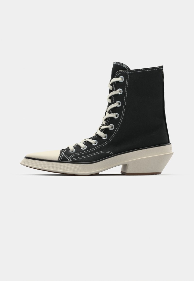 Stivaletto in canvas alto nero con lacci bianchi, punta crema e tacco angolare crema distintivo. Dettagli cuciti in bianco.