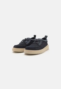 Dark blue suede shoes with a rounded toe, beige rubber sole, lacing system, and a rear tab for easy wear.