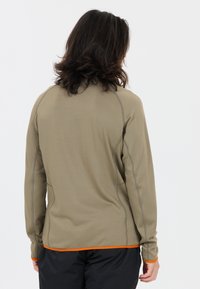 Långärmad skjorta i olivgrön tyg med texturerat mönster, med orange kant vid fållen och kragen. Sömsynlig detaljer är synlig.