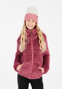 Fleecejacka i mörkrosa med hög krage, dragkedjeförslutning och framfickor. Kombinerad med en ljusrosa och krämfärgad stickad mössa.