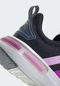 Černá síťovaná teniska se šedými akcenty a růžovým polstrováním na patě. Má bílou střední podrážku a šedou gumovou podrážku s rýhami.