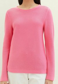 Rosa langärmeliger gerippter Pullover mit rundem Halsausschnitt, der eine subtile horizontale Textur aufweist. Leichtes Material, taillierte Passform.