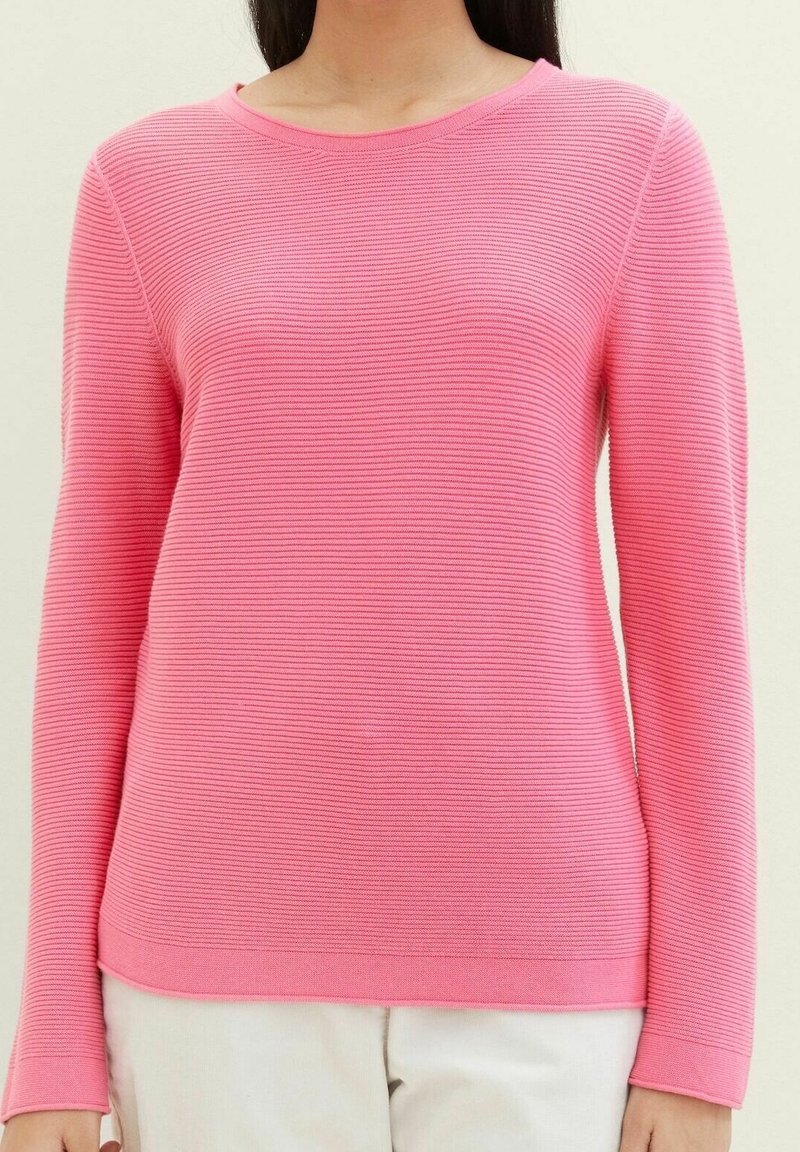Rosa langärmeliger gerippter Pullover mit rundem Halsausschnitt, der eine subtile horizontale Textur aufweist. Leichtes Material, taillierte Passform.