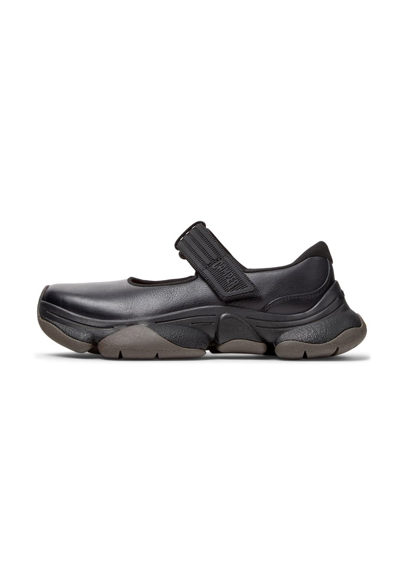 Scarpa stile Mary Jane nera con una cinghia texturizzata, design minimalista, suola in gomma flessibile e tomaia in pelle liscia.