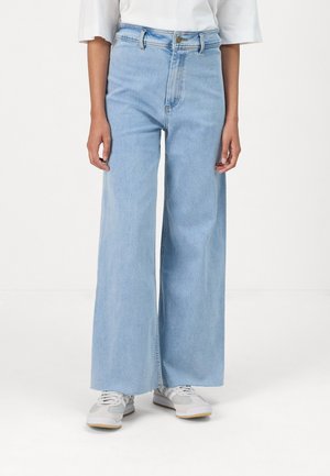 Jeans de denim bleu clair à jambes larges, avec une taille haute, une fermeture à bouton sur le devant et une silhouette droite épurée.
