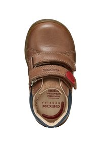 Scarpa in pelle marrone con una chiusura in Velcro, punta arrotondata e dettagli blu. L'interno presenta un marchio rosso su sfondo crema. Texture liscia.