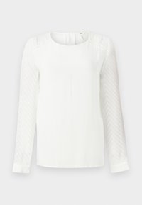 Blouse blanche à manches longues avec un col arrondi, présentant des manches translucides texturées et une coupe légèrement ample. Design simple sans motifs.