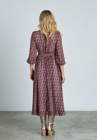 Lila gemustertes Kleid mit langen Ärmeln, geraffter Taille, knielangem Saum, strukturiertem Stoff und mehrlagigen Rüschendetails an den Ärmeln.