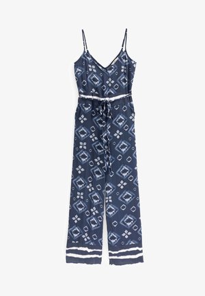 Marineblauwe mouwloze jumpsuit met wit geometrisch patroon, verstelbare tailleband en dunne schouderbandjes.