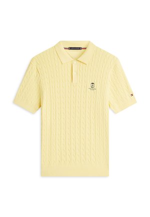 Bladożółta, krótka dzianinowa koszulka polo z krótkim rękawem, ze wzorem warkocza, dwoma guzikami, kołnierzykiem oraz małym haftowanym logo na piersi i rękawie.