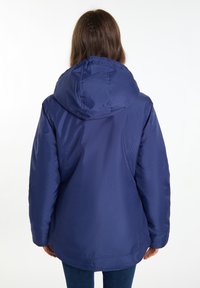 Giacca impermeabile blu navy con cappuccio, caratterizzata da una superficie liscia e una vestibilità comoda, cuciture visibili e un'orlo posteriore più lungo.