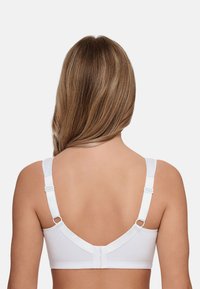 White bra with adjustable straps, a smooth material, and a U-shaped back design featuring hook-and-eye closure and decorative hardware.