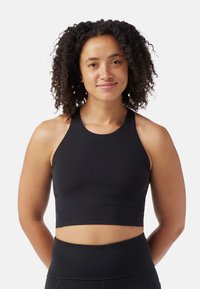 Musta aktiivinen lyhyt toppi, jossa on korkea kaula-aukko ja hihaton muotoilu. Sileä, joustava kangas ja tiukka istuvuus, täydellinen treeneihin.