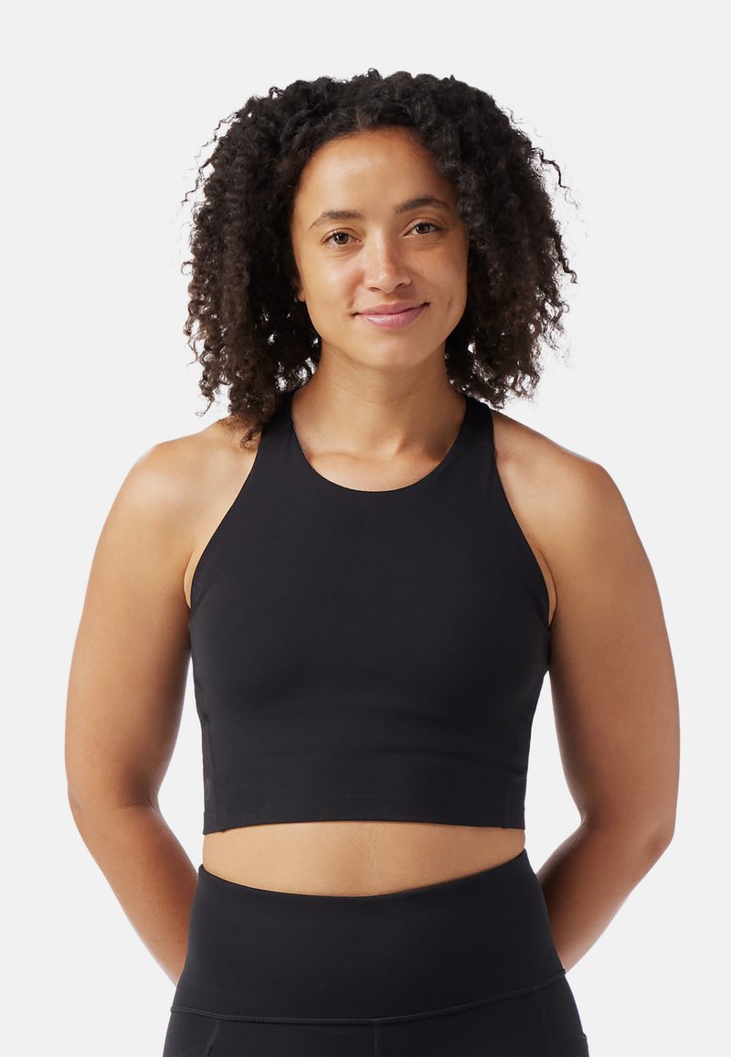 Musta aktiivinen lyhyt toppi, jossa on korkea kaula-aukko ja hihaton muotoilu. Sileä, joustava kangas ja tiukka istuvuus, täydellinen treeneihin.