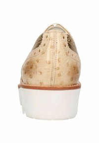Chaussure en cuir beige clair avec un motif texturé et des perforations, semelle extérieure blanche et un talon arrondi, montrant la vue arrière avec des accents minimalistes.
